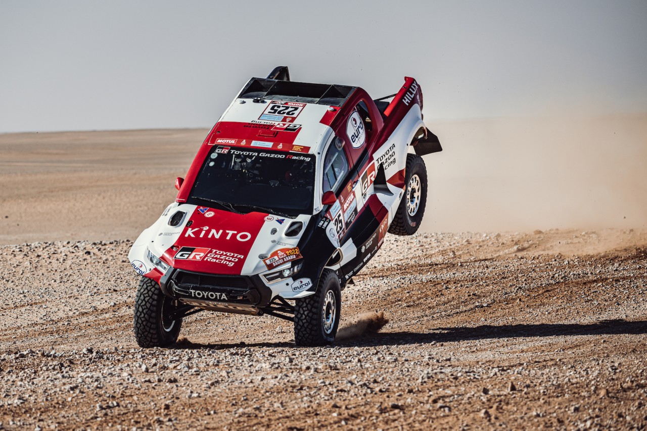 Rally car driving over a dune